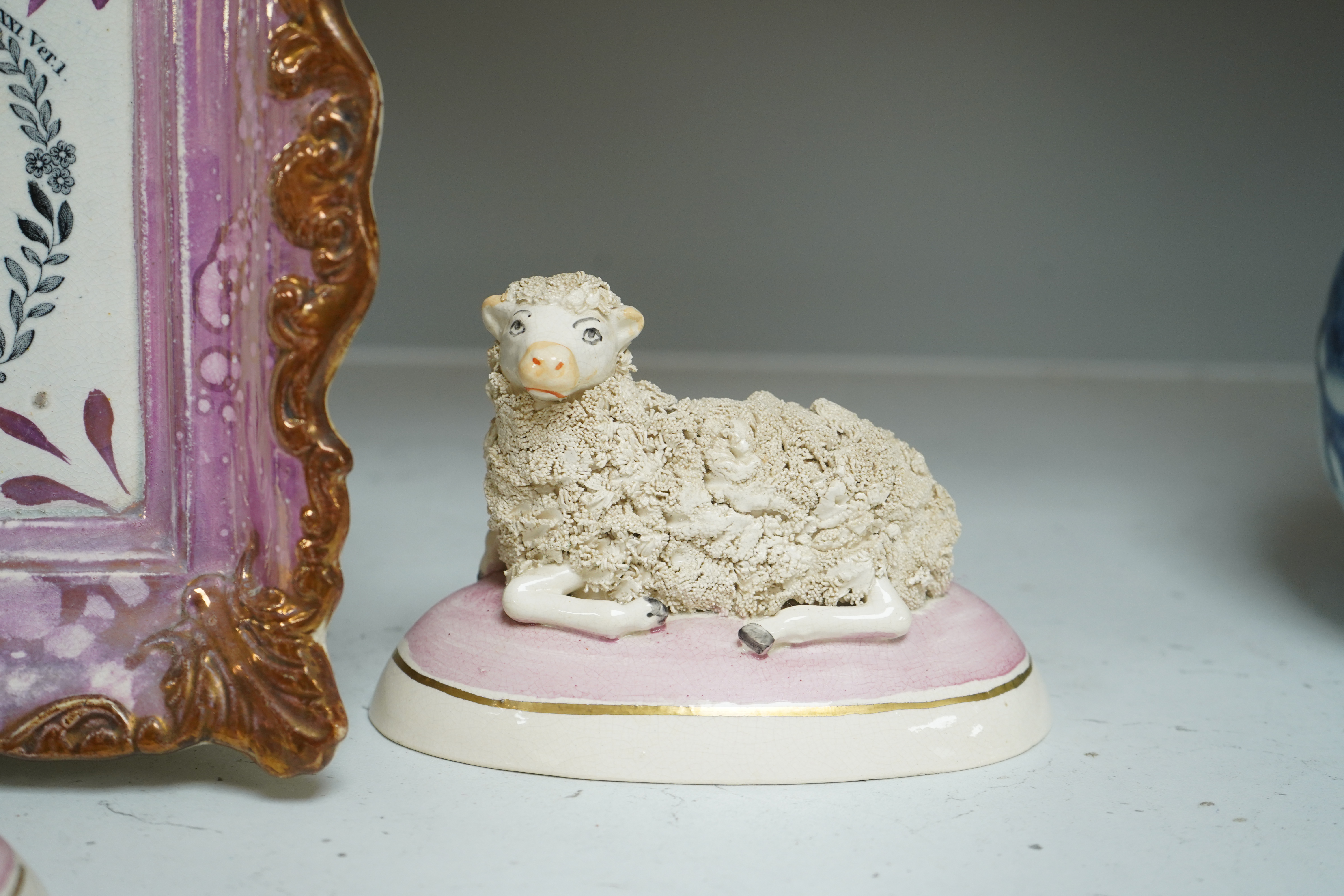 An 19th century Sunderland pink lustre wall plaque and two Staffordshire-style models of recumbent sheep, dish 24cm wide. Condition - good